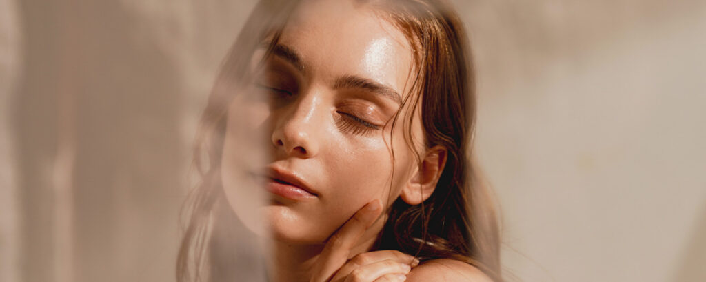 Mujer con piel luminosa después de un tratamiento facial con hielo, resaltando su brillo natural. 