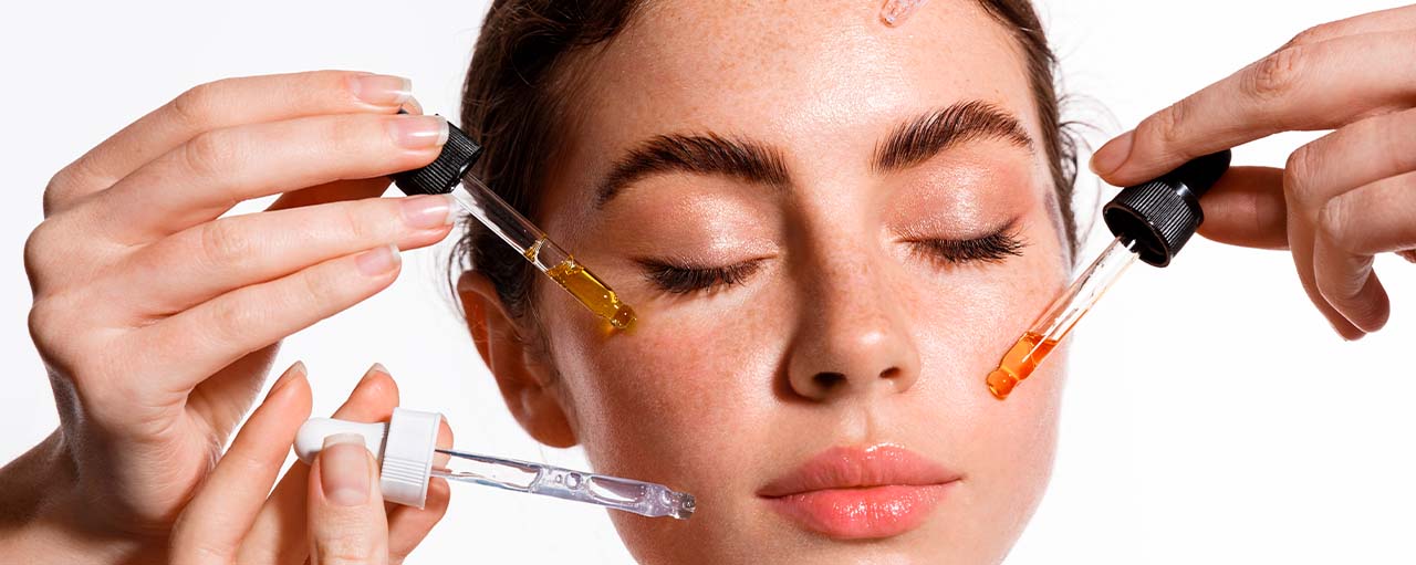 Mujer aplicando sérums en su rostro como parte de su rutina de hidratación facial