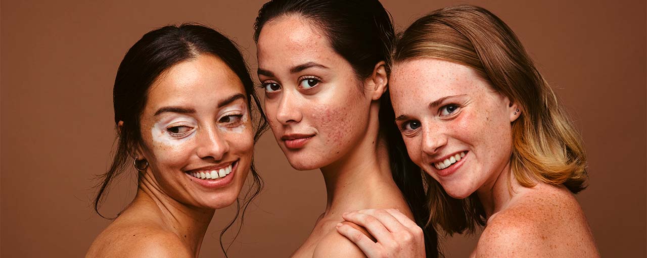 Tres mujeres con diferentes tipos de piel aplicando crema en el rostro