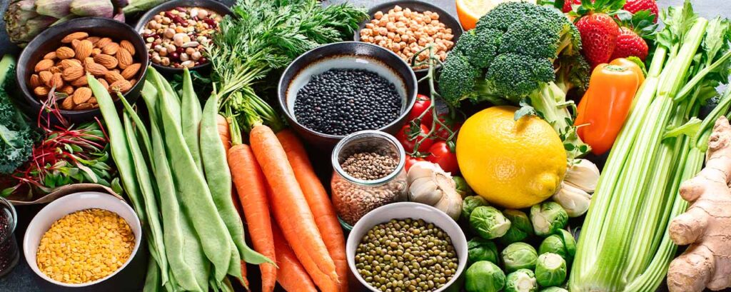 Variedad de alimentos ricos en Vitamina K para la cara, como verduras, frutos secos y legumbres